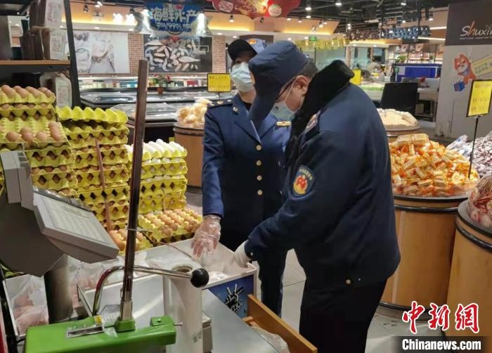圖為疫情期間，甘肅嘉峪關(guān)市場監(jiān)管局工作人員檢查蔬菜市場?！?柴佳楠 　攝