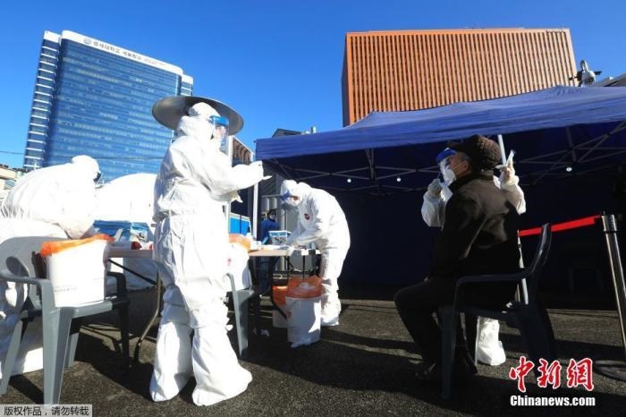 資料圖：韓國首爾，醫(yī)務(wù)人員對市民進(jìn)行新冠病毒檢測。