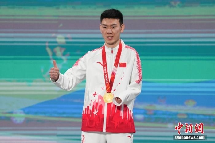 3月6日，梁景怡在延慶頒獎(jiǎng)廣場領(lǐng)獎(jiǎng)臺(tái)上豎起大拇指。當(dāng)日，在國家高山滑雪中心舉行的北京2022年冬殘奧會(huì)殘奧高山滑雪男子超級(jí)大回轉(zhuǎn)—站姿決賽中，中國選手梁景怡奪得冠軍。 <a target='_blank' href='/'>中新社</a>記者 楊華峰 攝