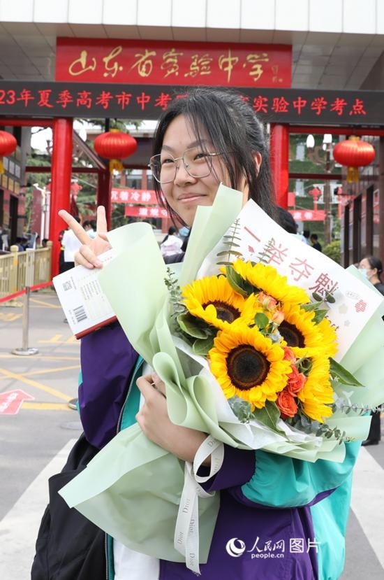 6月7日高考首日，山東67萬考生走進(jìn)考場，拼搏逐夢。在山東省實(shí)驗(yàn)中學(xué)考點(diǎn)，考生進(jìn)考場前手捧向日葵花拍照留念，寓意“一舉奪魁”。人民網(wǎng)記者 劉祺攝