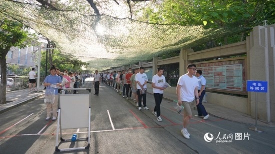 6月7日，烏魯木齊市第七十中學(xué)門口，考生們有序進(jìn)入考場。人民網(wǎng) 李欣洋攝