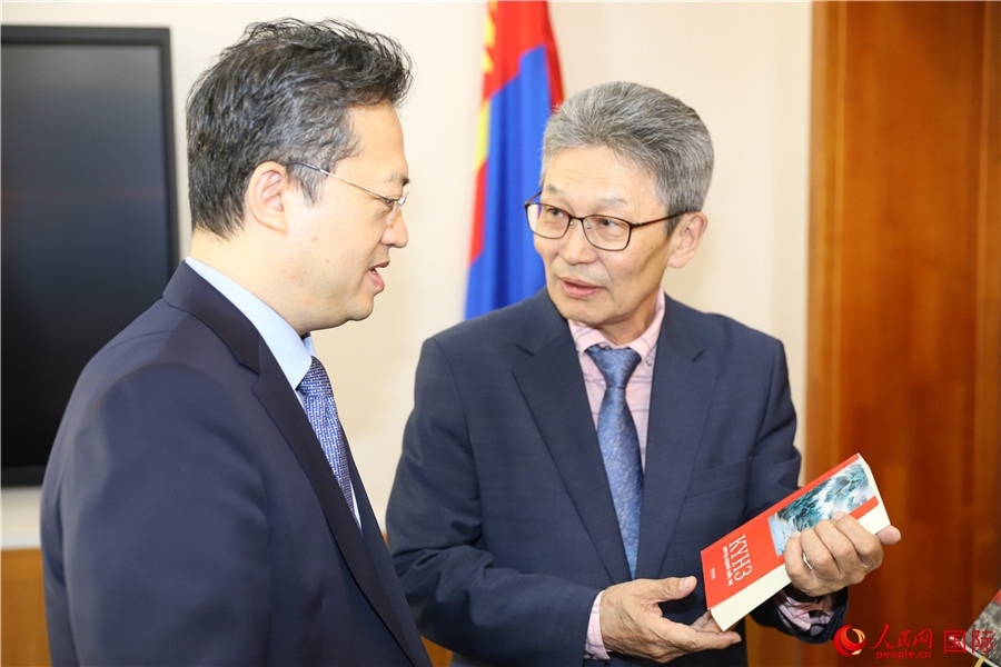 其米德策耶（右一）向李峙介紹翻譯成果。人民網(wǎng)記者 霍文攝