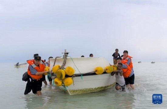 7月21日，中國(guó)海軍“和平方舟”號(hào)醫(yī)院船醫(yī)護(hù)人員涉水登島，前往基里巴斯一診療點(diǎn)。新華社記者 黎云 攝