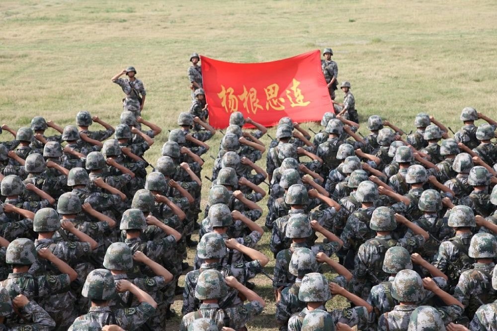 ↑“楊根思連”官兵執(zhí)行任務(wù)前向連旗宣誓（資料照片）。新華社發(fā)