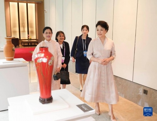 7月27日下午，國家主席習近平夫人彭麗媛在四川成都會見陪同印度尼西亞總統(tǒng)佐科來華出席第31屆世界大學生夏季運動會開幕式并訪華的總統(tǒng)夫人伊莉亞娜。這是彭麗媛和伊莉亞娜欣賞成都特色非遺工藝品。新華社記者 丁林 攝