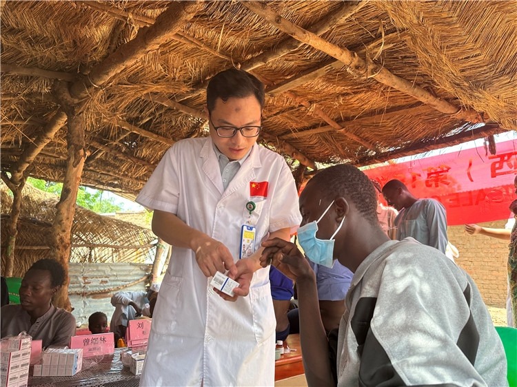 圖為南昌大學(xué)第一附屬醫(yī)院病理科主治醫(yī)師張振東為村民解說(shuō)藥品使用方法。中國(guó)駐乍得醫(yī)療隊(duì)供圖