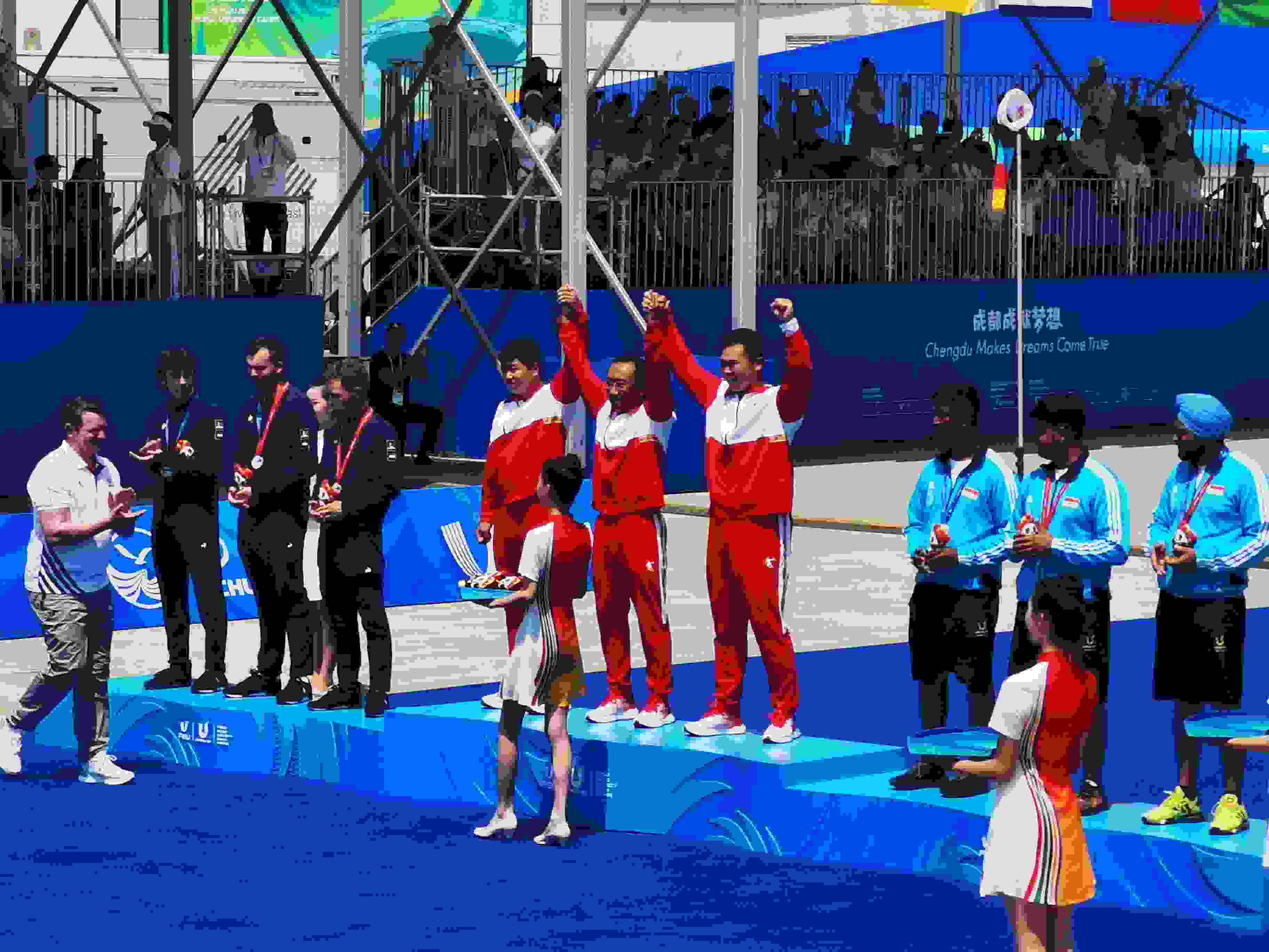 7月30日，在成都大運會男子復(fù)合弓團體頒獎儀式中，中國隊慶祝奪得冠軍。 人民網(wǎng)記者 楊磊攝