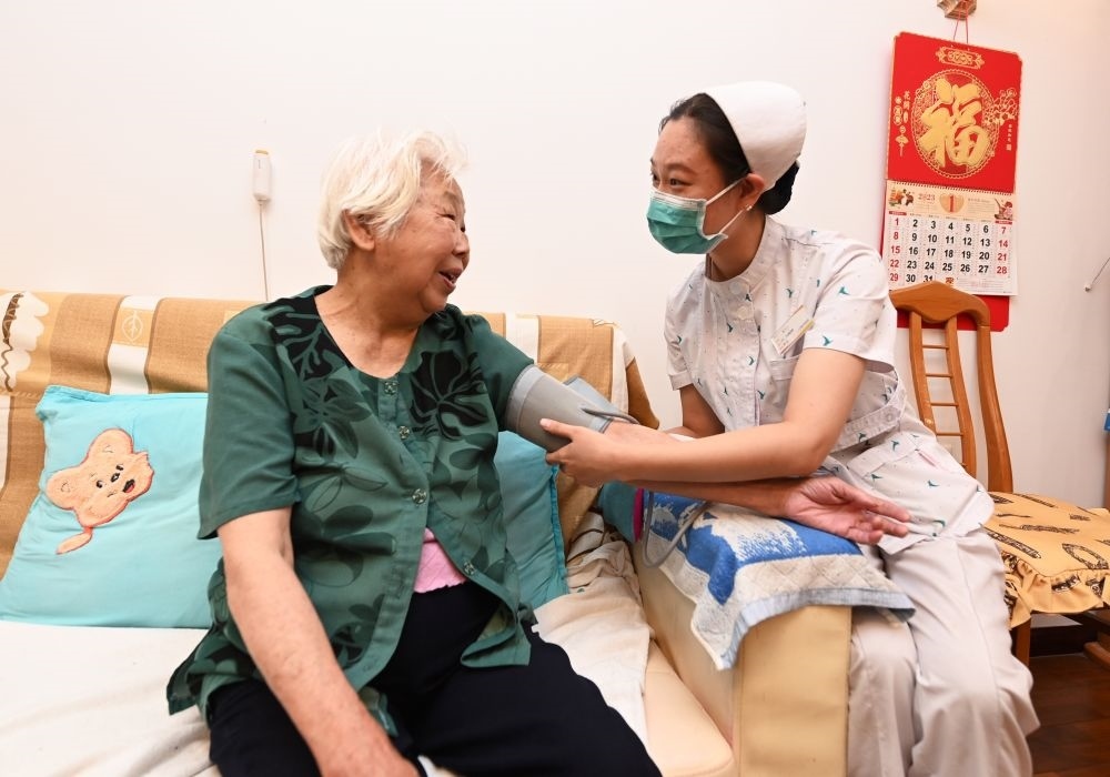 河北廊坊三河市燕達(dá)金色年華健康養(yǎng)護(hù)中心醫(yī)務(wù)人員為入住老人測量血壓（2023年7月20日攝）。新華社記者 朱旭東 攝