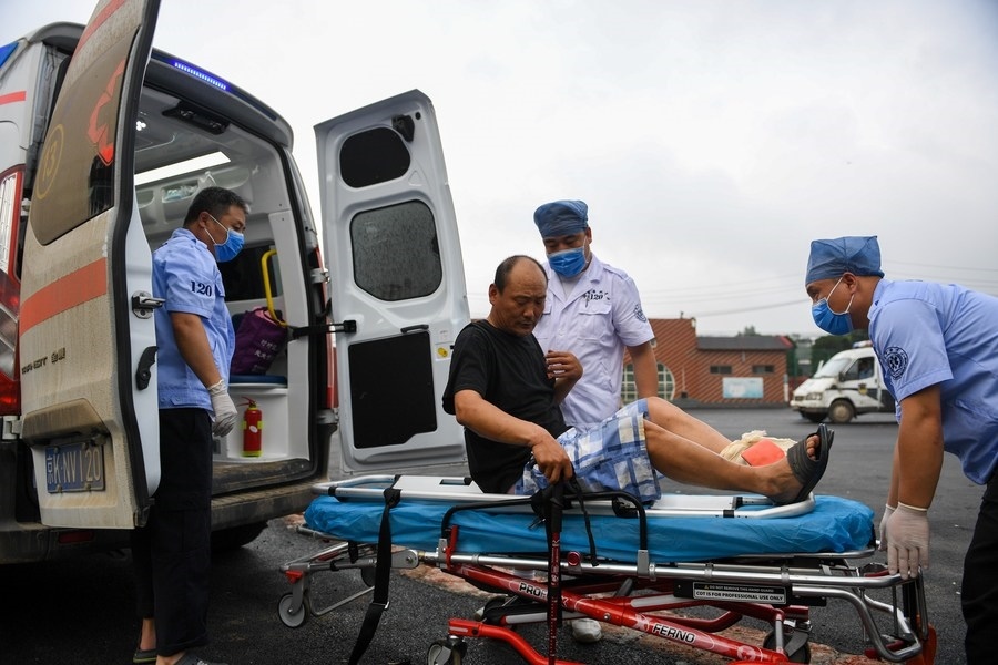 8月1日，在北京市門(mén)頭溝區(qū)妙峰山鎮(zhèn)妙峰山民族學(xué)校臨時(shí)安置點(diǎn)，北京急救中心工作人員在轉(zhuǎn)運(yùn)一名受傷村民。新華社記者 鞠煥宗 攝