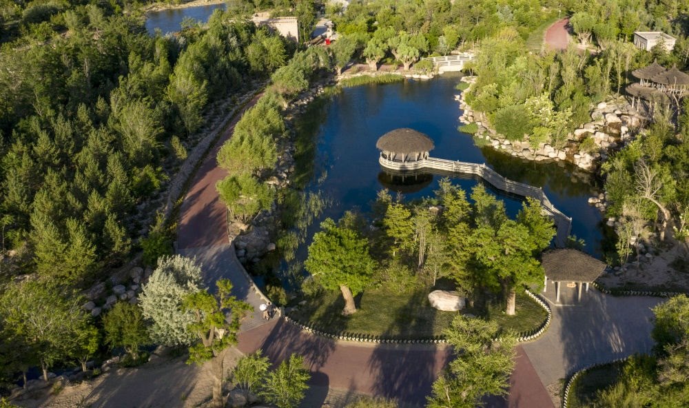 坐落在寧夏銀川市賀蘭山腳下的賀蘭山運動休閑公園（2021年5月27日攝，無人機照片）。這里曾是一片砂石采礦塌陷區(qū)，當(dāng)?shù)赝ㄟ^植被景觀再造、水系建設(shè)、現(xiàn)代管網(wǎng)鋪建等手段，重新利用廢石、廢坑及各類廢棄建筑材料，把這里變成一座免費開放的主題公園。新華社記者 馮開華 攝