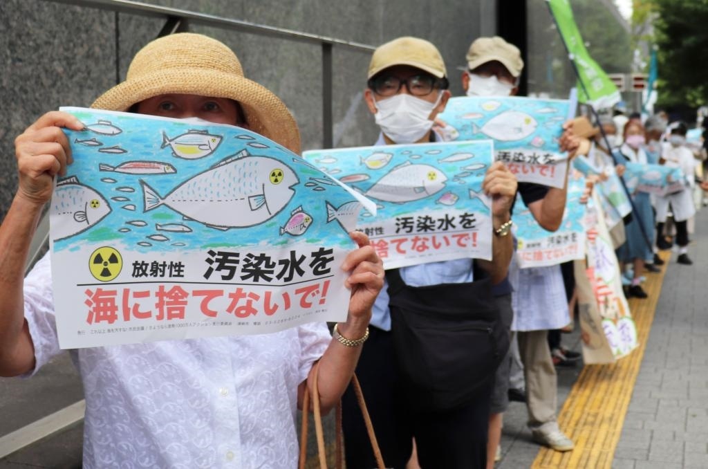8月24日，日本民眾手持“不要將污染水扔進大?！钡葮苏Z在東京電力公司總部前集會，抗議日本政府和東電公司無視民意啟動核污染水排海。新華社記者楊光攝