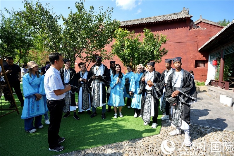 圖為選手們聽(tīng)導(dǎo)游講解。人民網(wǎng) 盧鵬宇攝