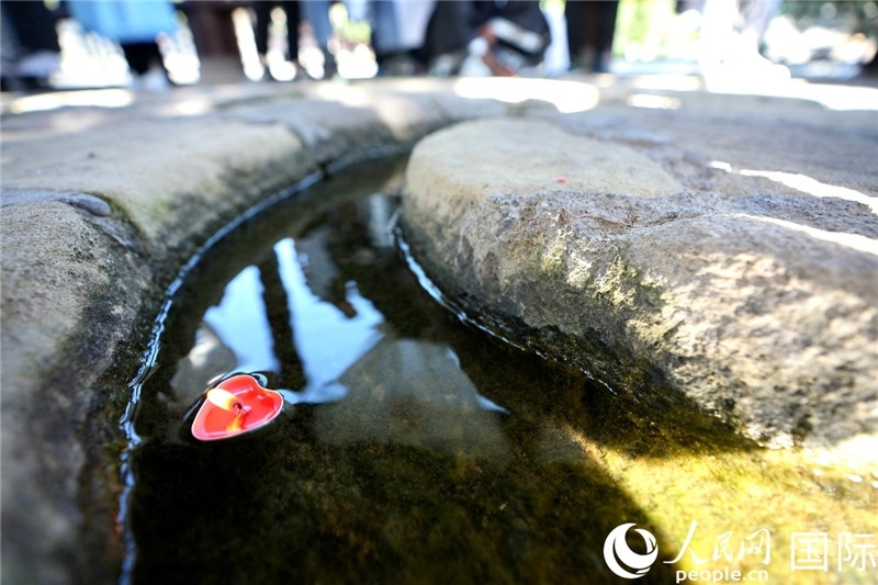 圖為水渠里流過(guò)的“桃心”蠟燭。人民網(wǎng) 盧鵬宇攝