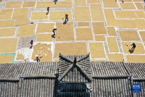 9月16日，村民在貴州省黔東南苗族侗族自治州從江縣剛邊壯族鄉(xiāng)三聯(lián)村晾曬稻谷（無人機照片）。