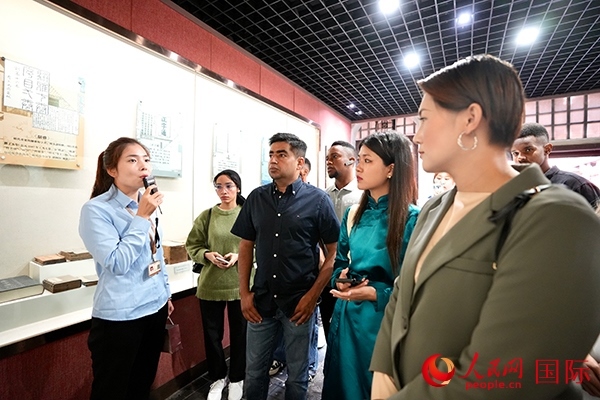 選手們認(rèn)真聆聽導(dǎo)游講解。人民網(wǎng) 盧鵬宇攝