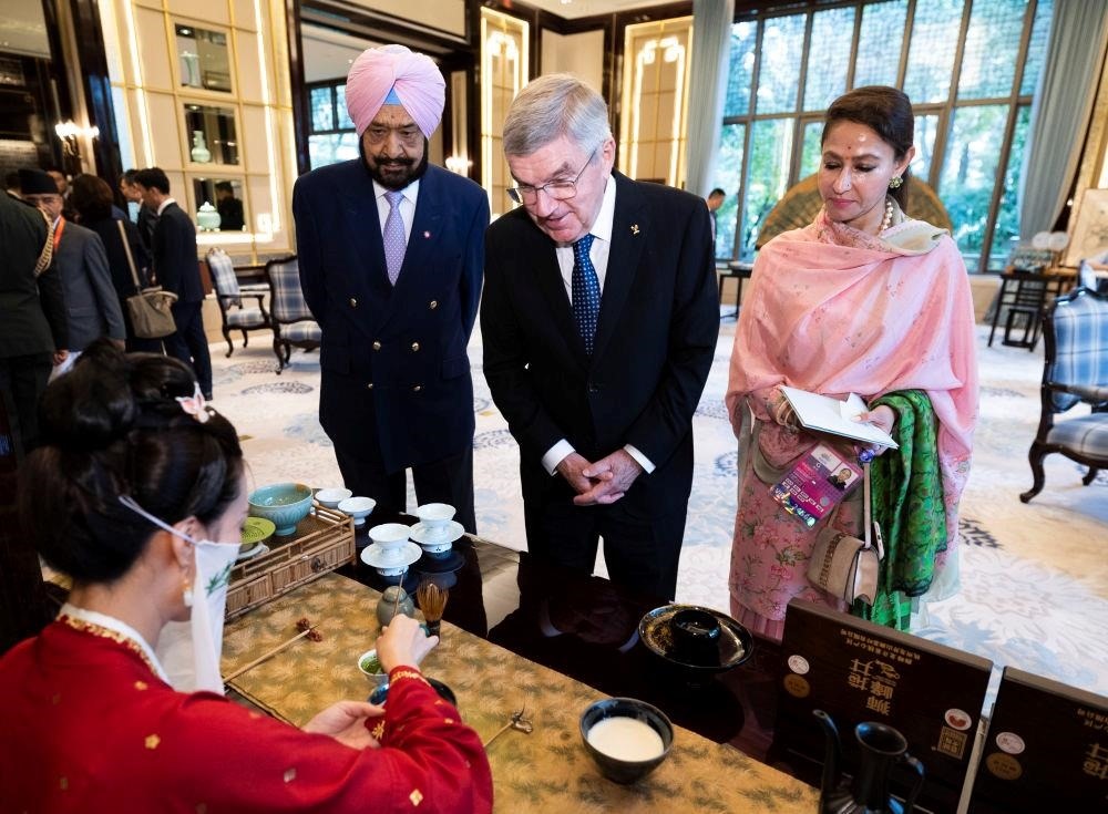 △歡迎宴會前，亞奧理事會代理主席辛格和夫人維尼塔、國際奧委會主席巴赫欣賞非遺展示。