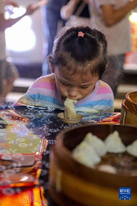 9月27日，小朋友在南翔小籠長街宴上品嘗南翔小籠。