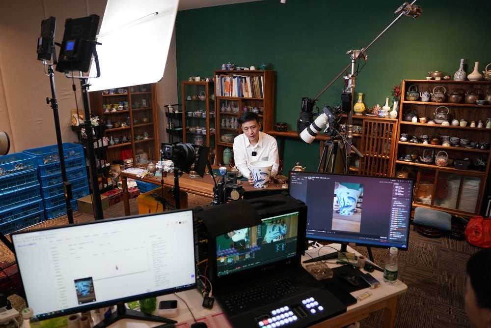 ↑在景德鎮(zhèn)，工作人員通過(guò)網(wǎng)絡(luò)直播推介陶瓷產(chǎn)品（2023年2月22日攝）。