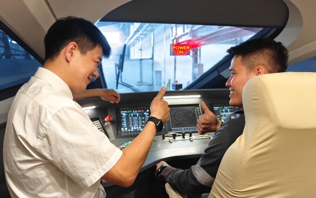 8月25日，在印度尼西亞萬(wàn)隆的雅萬(wàn)高鐵德卡魯爾動(dòng)車(chē)所內(nèi)，中國(guó)師傅穆振（左）在向印尼火車(chē)司機(jī)塞蒂亞萬(wàn)講解動(dòng)車(chē)組出庫(kù)前的上電作業(yè)。