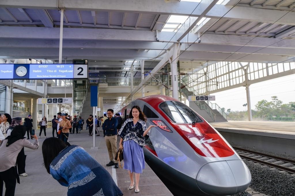 10月17日，在印度尼西亞萬(wàn)隆德卡魯爾站，乘客在站臺(tái)上和雅萬(wàn)高鐵高速動(dòng)車(chē)組列車(chē)合影。
