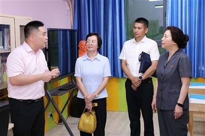 圖③：“小公民法律課堂”開講前，全國(guó)人大代表殷其龍（右二）、重慶市人大代表李自玲（左二）聽取楊家坪中學(xué)負(fù)責(zé)人關(guān)于未成年人思想教育工作情況的介紹。