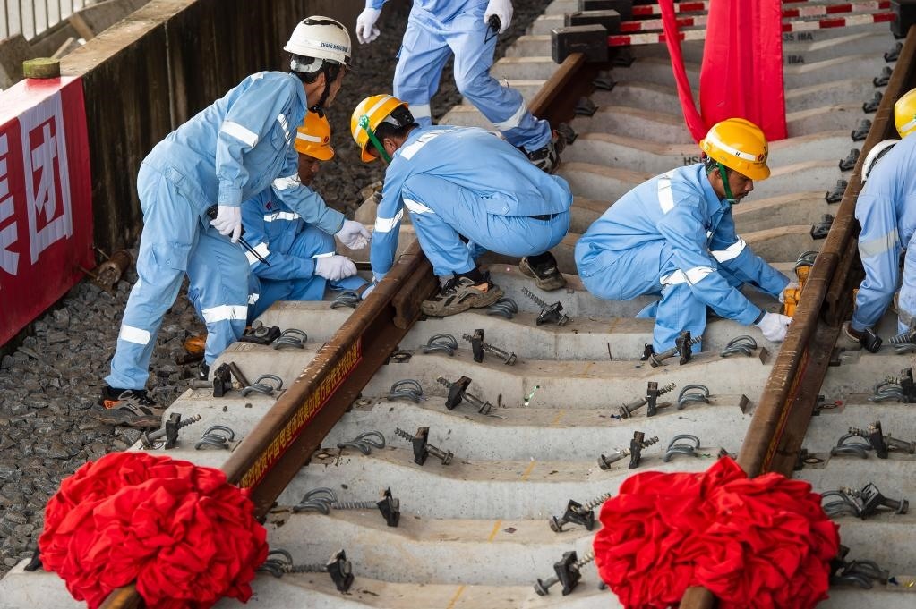 3月31日，在印度尼西亞雅加達(dá)雅萬(wàn)高鐵哈利姆車(chē)站，工人鋪設(shè)雅萬(wàn)高鐵全線最后一根鋼軌。