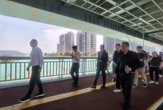 10月24日，2023“一帶一路”媒體合作論壇聯(lián)合采訪團(tuán)團(tuán)員走在清水塘大橋景觀通道上。本報記者 常雯宜攝