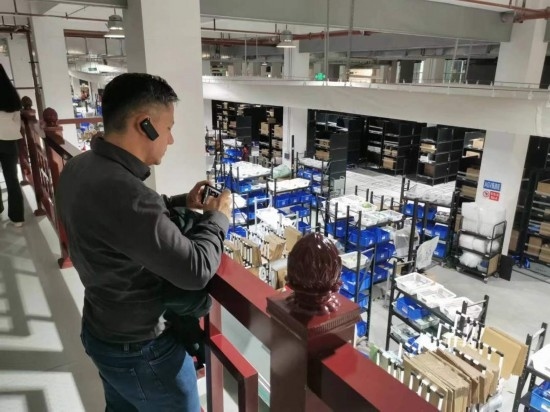 2023“一帶一路”媒體合作論壇聯(lián)合采訪團(tuán)團(tuán)員在仁和醫(yī)藥物流園拍攝記錄轉(zhuǎn)運(yùn)流程。（本報記者 黃超攝）