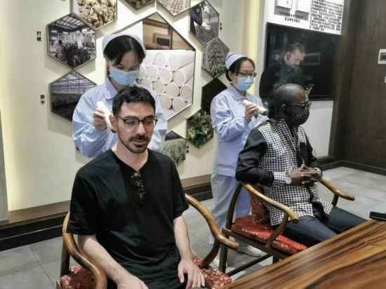 2023“一帶一路”媒體合作論壇聯(lián)合采訪團(tuán)團(tuán)員在九牛草展示館體驗艾灸。（本報記者 黃超攝）