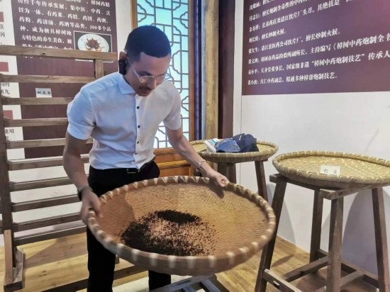 2023“一帶一路”媒體合作論壇聯(lián)合采訪團(tuán)團(tuán)員在非遺文化展示館體驗中藥炮制技藝。（本報記者 黃超攝）