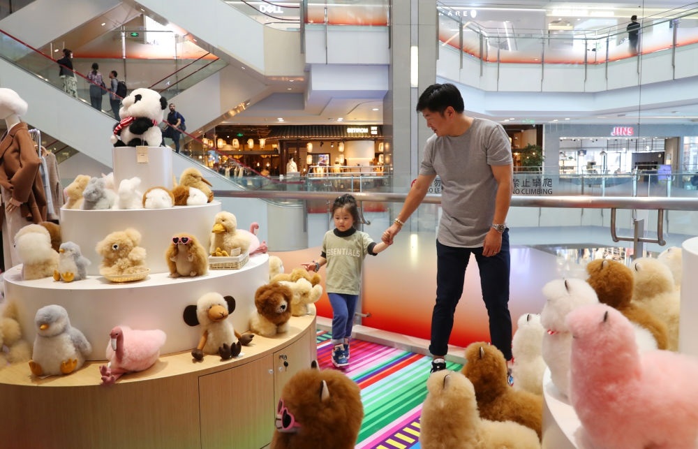 2023年11月2日，顧客在溫暖駝品牌專柜內(nèi)選購(gòu)。連續(xù)六年參加進(jìn)博會(huì)的秘魯羊駝制品品牌溫暖駝在上海市中心商場(chǎng)開(kāi)設(shè)了專柜。新華社記者 方喆 攝