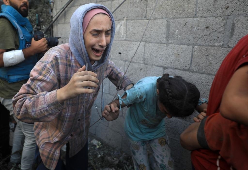 11月6日，人們從加沙地帶中部地區(qū)一處被炸難民營逃離。新華社發(fā)（亞西爾·庫迪攝）