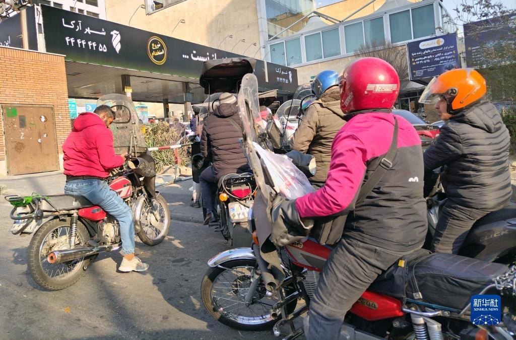 12月18日，摩托車在伊朗首都德黑蘭的一家加油站外等待加油。新華社記者 沙達(dá)提 攝