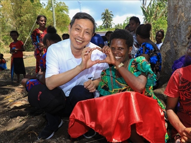 2023年12月18日，中國駐瓦努阿圖大使李名剛和前來觀看瓦努阿圖公路項目二期馬勒庫拉段移交儀式的當?shù)鼐用窈嫌?。人民網(wǎng) 賀吉攝