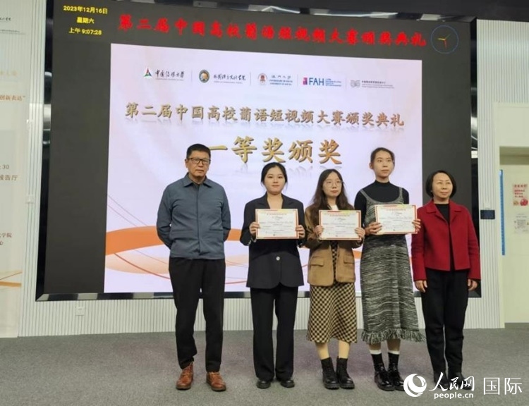 澳門大學(xué)中葡雙語教學(xué)暨培訓(xùn)中心主任姚京明（左一）和中國傳媒大學(xué)外國語言文化學(xué)院院長文春英（右一）為一等獎獲得者頒獎。人民網(wǎng)記者 魯揚攝