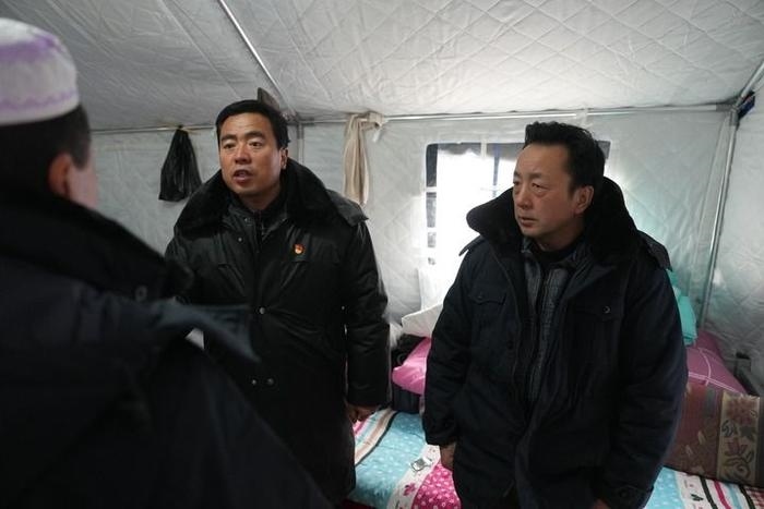 2023年12月22日，積石山縣大河家鎮(zhèn)大河村黨支部書記馬成忠（右二）在帳篷里和受災(zāi)群眾交流。新華社記者 陳斌 攝