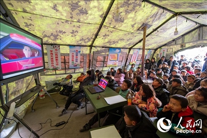 12月22日，在積石山縣大河家鎮(zhèn)大河村安置點(diǎn)，陸軍76集團(tuán)軍某旅搭建的“臨時學(xué)校”內(nèi)，小朋友正在看動畫片。人民網(wǎng)記者 翁奇羽攝