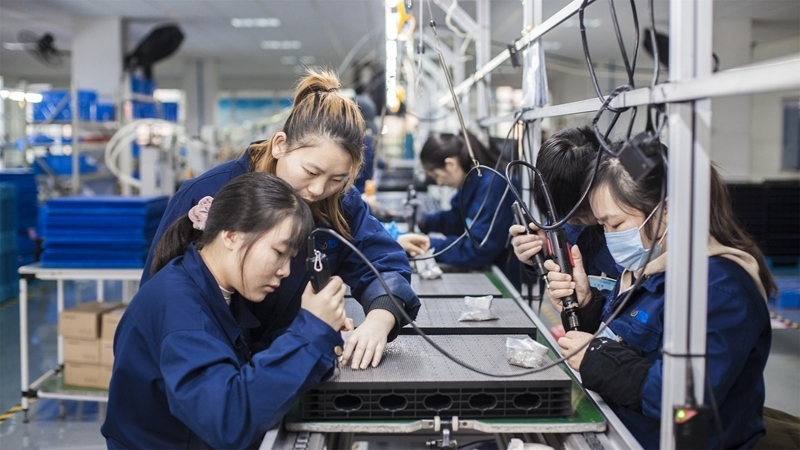 在新亞勝光電的產(chǎn)品線上，工人正進(jìn)行產(chǎn)品組建和安裝布線。受訪者供圖