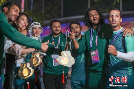 資料圖：9月29日，中國傳統(tǒng)節(jié)日中秋節(jié)，杭州亞運(yùn)會(huì)運(yùn)動(dòng)員村舉辦中秋主題活動(dòng)，中外運(yùn)動(dòng)員們歡聚一堂。圖為沙特阿拉伯運(yùn)動(dòng)員手持燈籠拍攝照片。<a target='_blank' href='/'><p align=