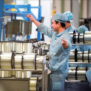 在位于武漢的長飛光纖光纜股份有限公司光纖生產(chǎn)車間內(nèi)，工作人員對光纖進行檢測（資料圖片）。肖藝九攝/本刊