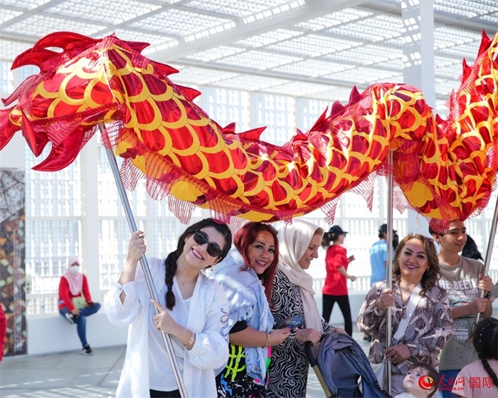 游客體驗舞龍。 人民網(wǎng) 塔里克·易卜拉欣攝