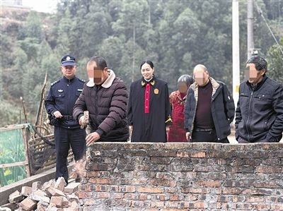  圖③：庭審結束后，在法官的見證下，陳某在院壩邊重新開鑿一條通道。