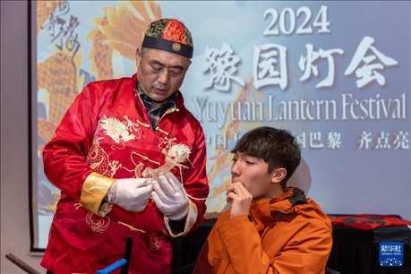 1月28日，在上海豫園舉行的民俗活動上，美國馬斯卡廷中學(xué)學(xué)生在非遺傳承人的指導(dǎo)下吹糖偶。 新華社記者 王翔 攝