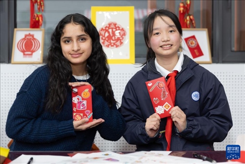 1月28日，美國馬斯卡廷中學(xué)學(xué)生（左）和復(fù)旦大學(xué)第二附屬學(xué)校學(xué)生展示互相送出的寫有寄語祝福的紅包。 新華社記者 王翔 攝