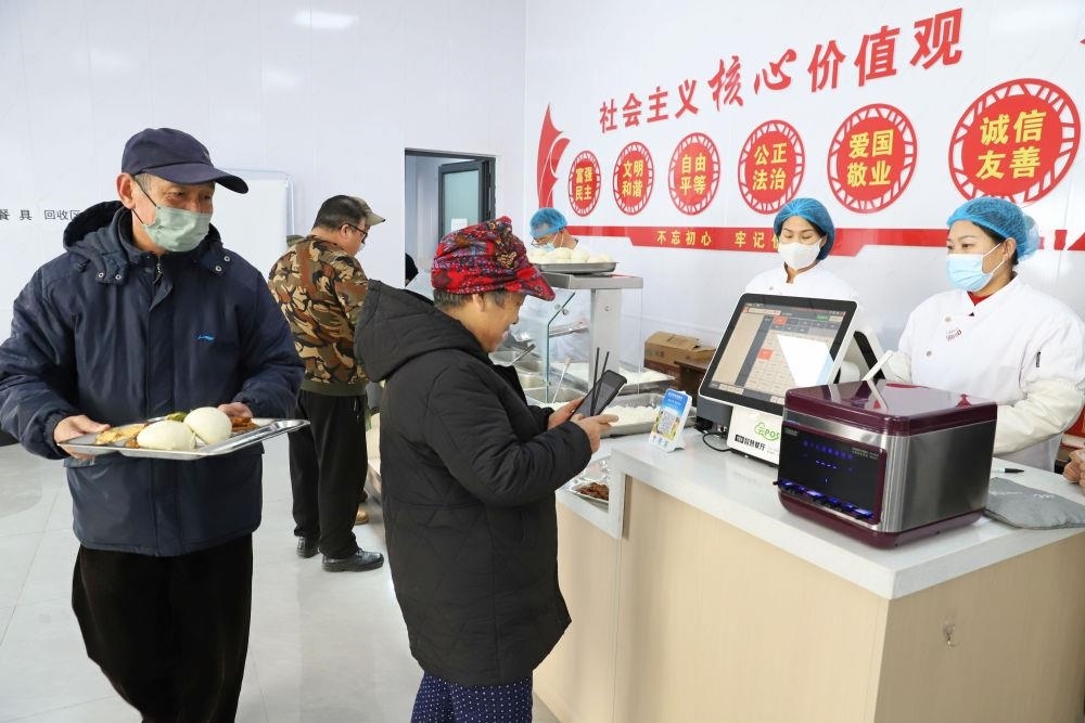 △2024年2月1日，市民在河北涿州市雙塔街道永濟(jì)秀園小區(qū)便民食堂內(nèi)購買午餐。