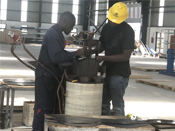 經(jīng)貿(mào)合作區(qū)廠房內(nèi)，當(dāng)?shù)毓と苏诰o張作業(yè)。人民網(wǎng)記者 黃培昭攝