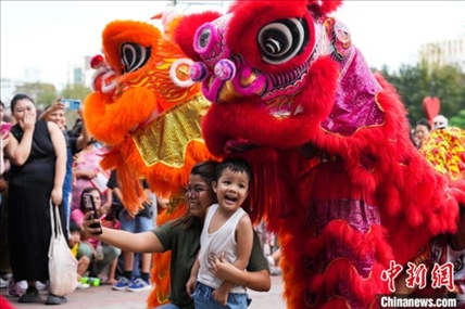 圖為舞獅表演吸引民眾合影。張興龍攝