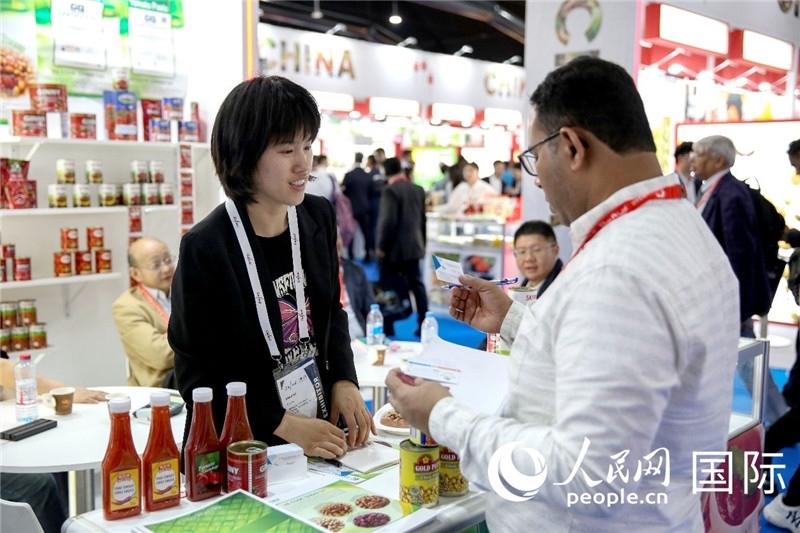 圖為中國參展企業(yè)代表與采購商交流。人民網(wǎng) 塔里克·易卜拉欣攝