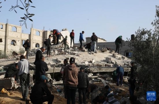 3月3日，在加沙地帶南部城市拉法，人們查看被以軍空襲破壞的建筑。新華社發(fā)（哈立德·奧馬爾攝）