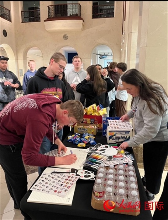 學(xué)生們出發(fā)前紛紛在留言簿留言。人民網(wǎng)記者 鄧圩攝